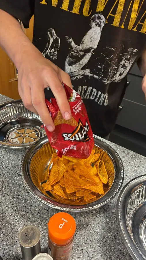 Adding crushed crisps to a coating bowl
